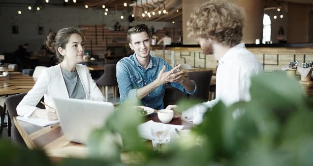 A group of colleagues working together in a cafe.